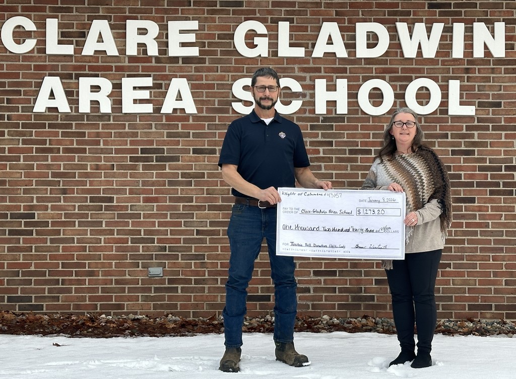 Clare Knights of Columbus Grand Knight Bruce Wentworth presents a donation to Clare Gladwin Area School Principal Beth Wood.