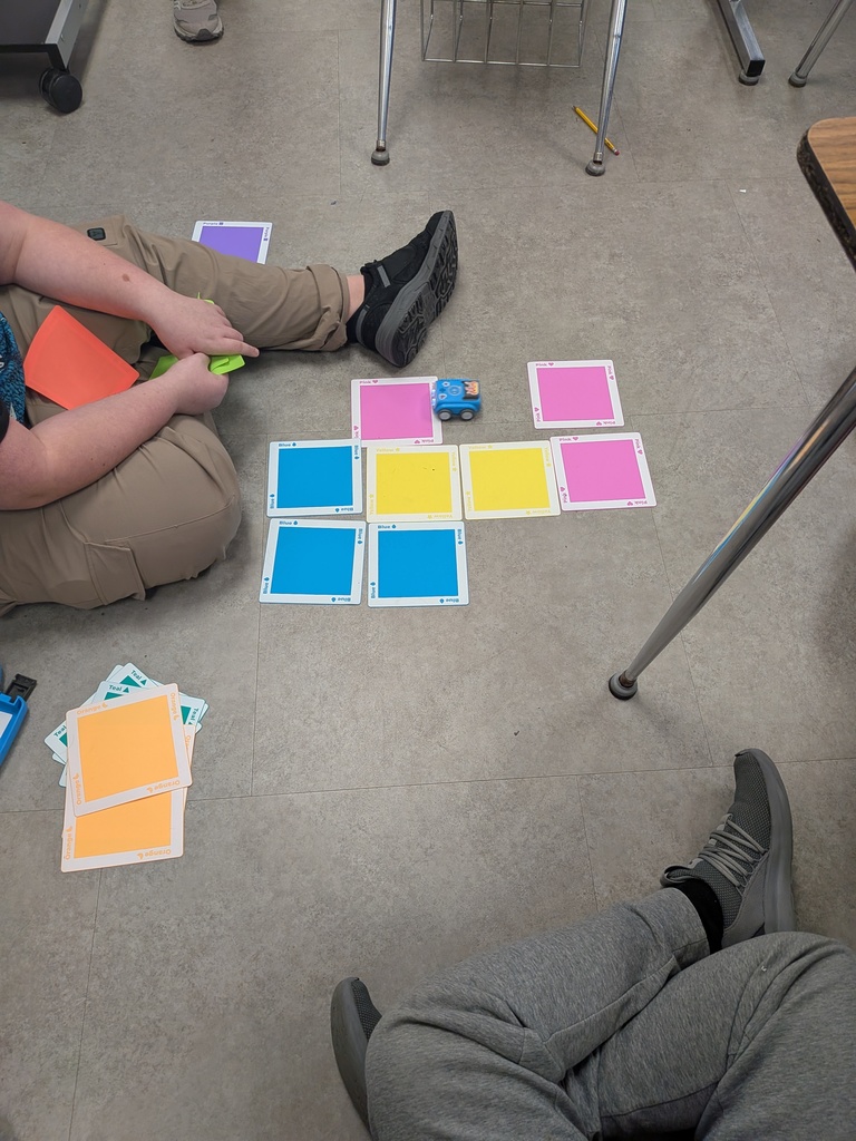 Students program a robot with colored pads.