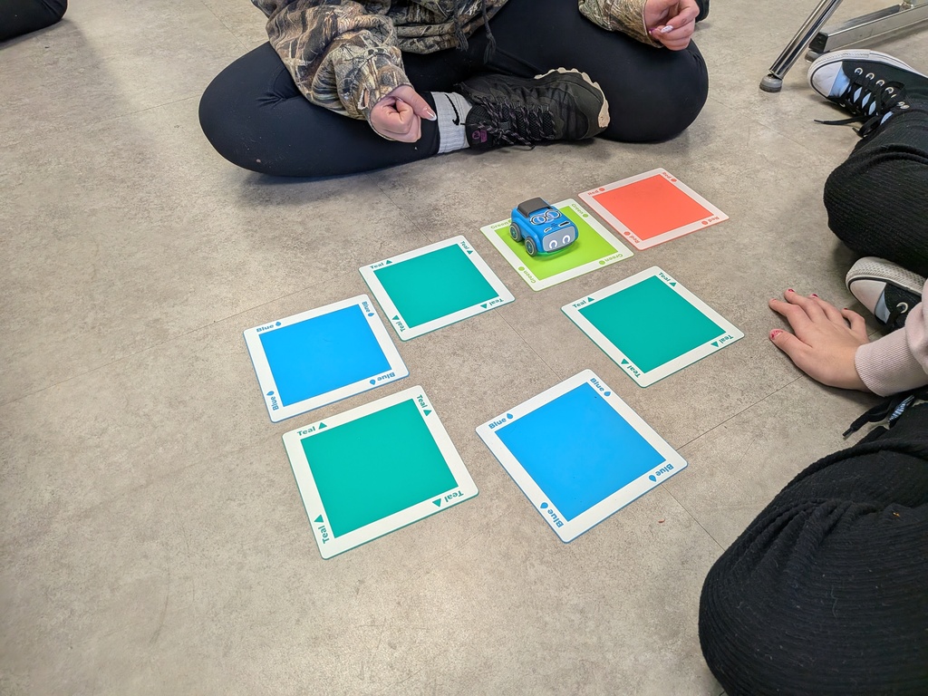 Students program a robot with colored pads.