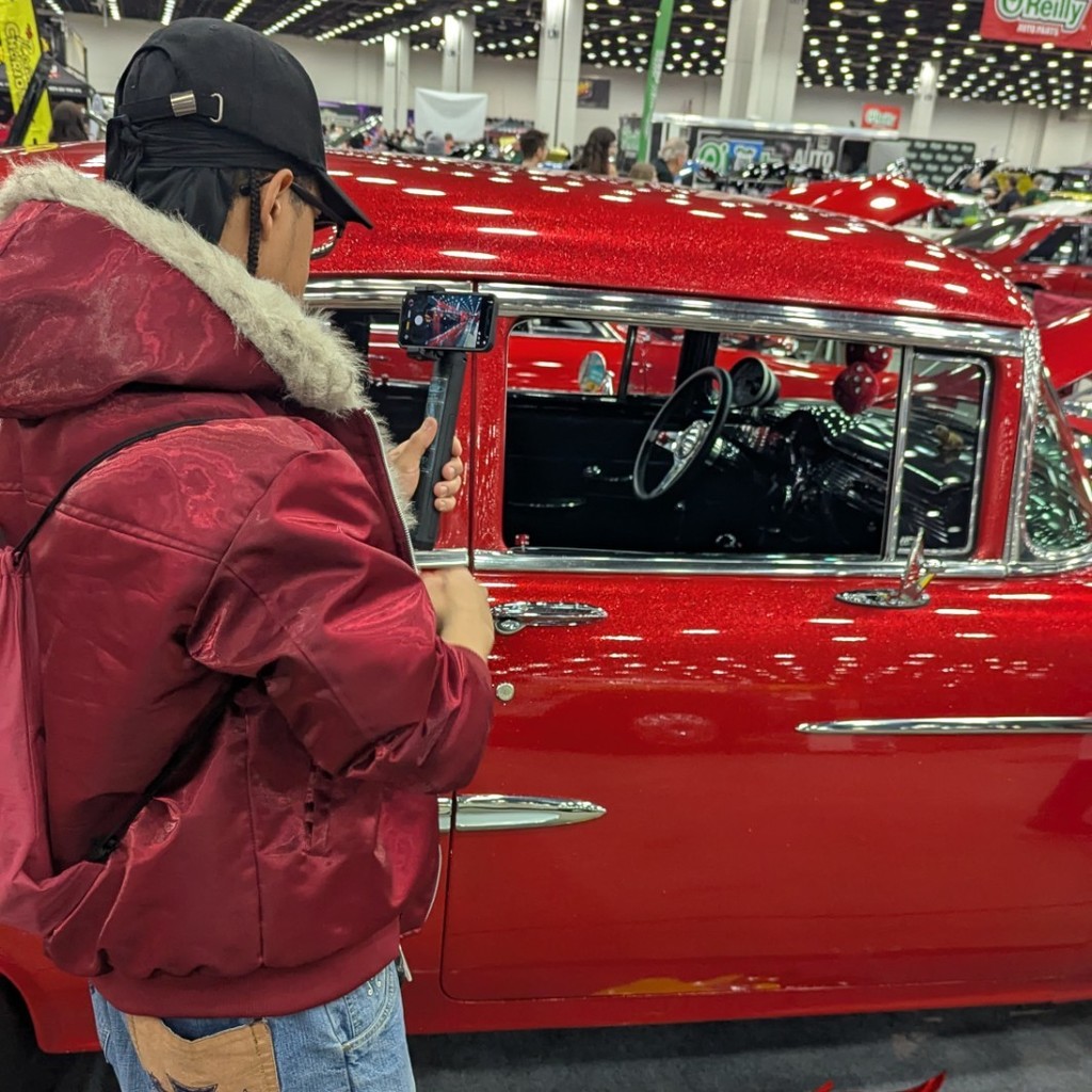 A student takes a picture of the inside of a classic Chevy Bel Air