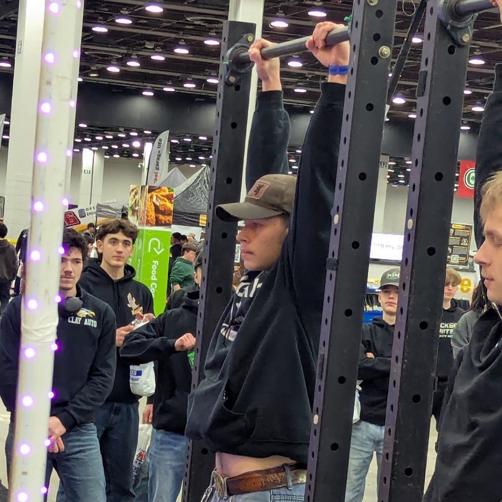 A student takes part in a handing bar challenge. the goal was to hang for two minutes.