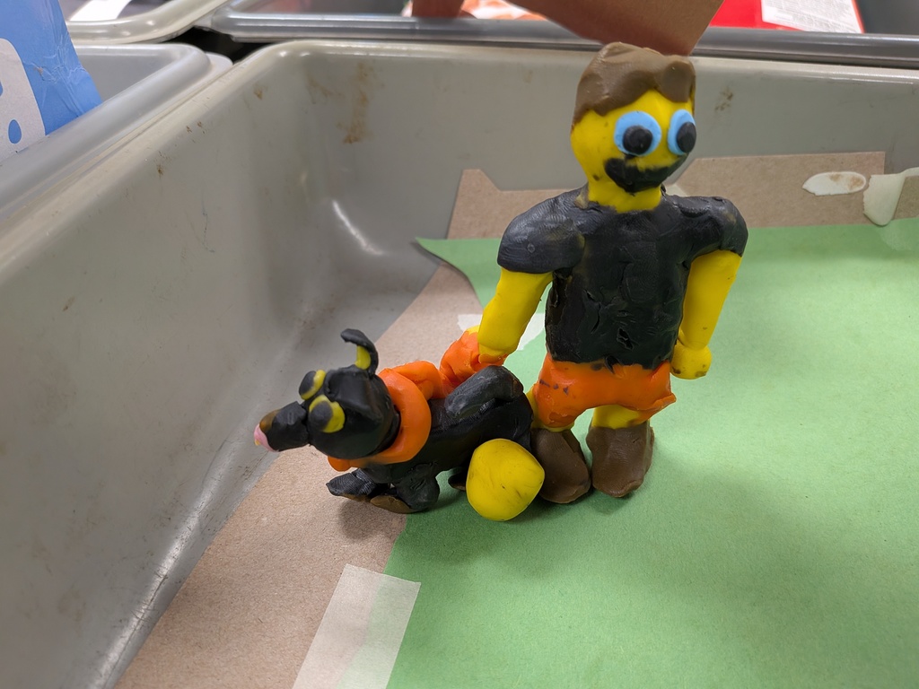 A clay person and dog made by students.