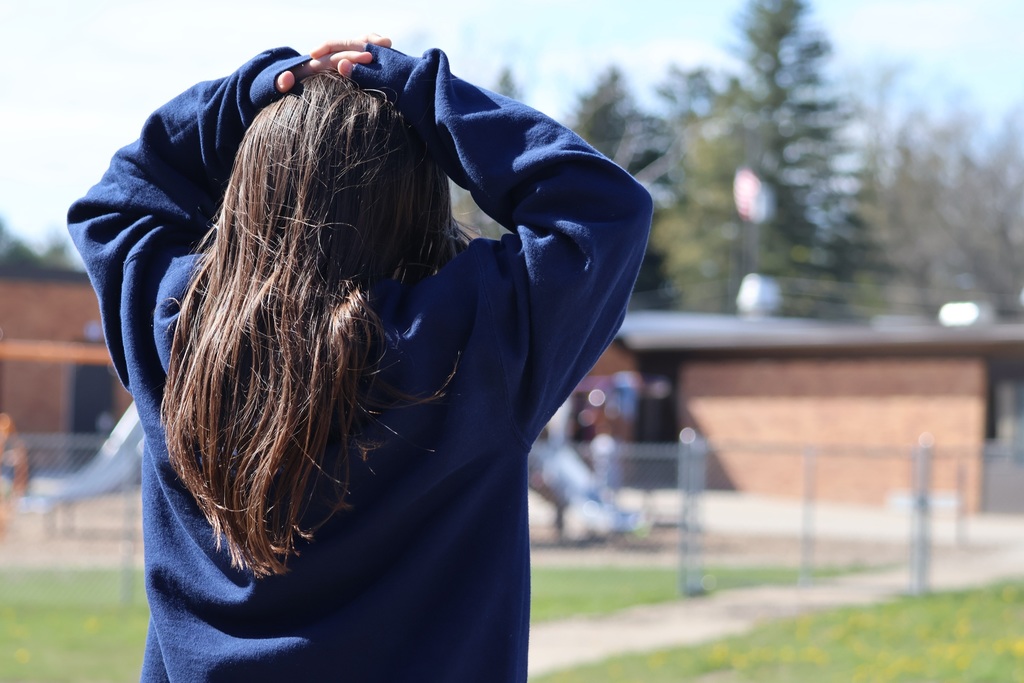 A student watches a drone in the air to make sure it is safe.