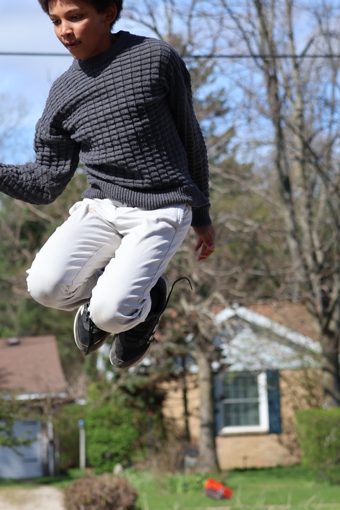A student jumps in the air as students take high speed photos.