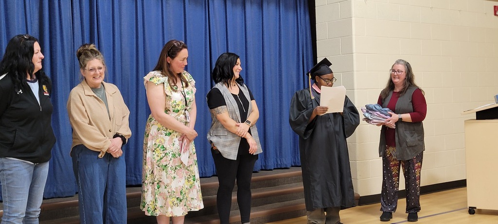 Giving her speech at graduation, along with a fun twist, as she handed out backpacks to staff because her backpack has become so meaningful to others.