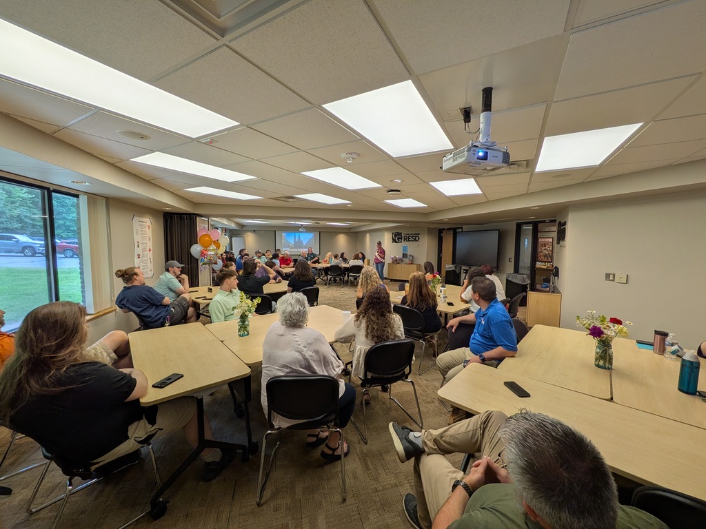 A group watches  Stacey Beebe give a farewell speech.