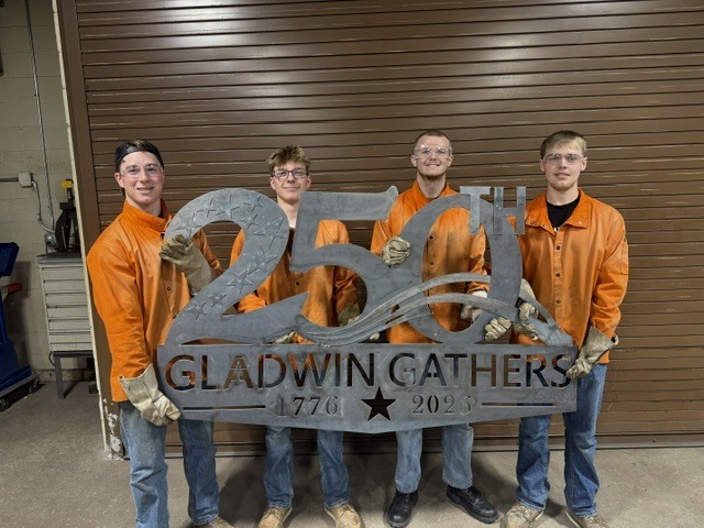 Welding Students holding the 250th Celebration Sign they created  for parades.