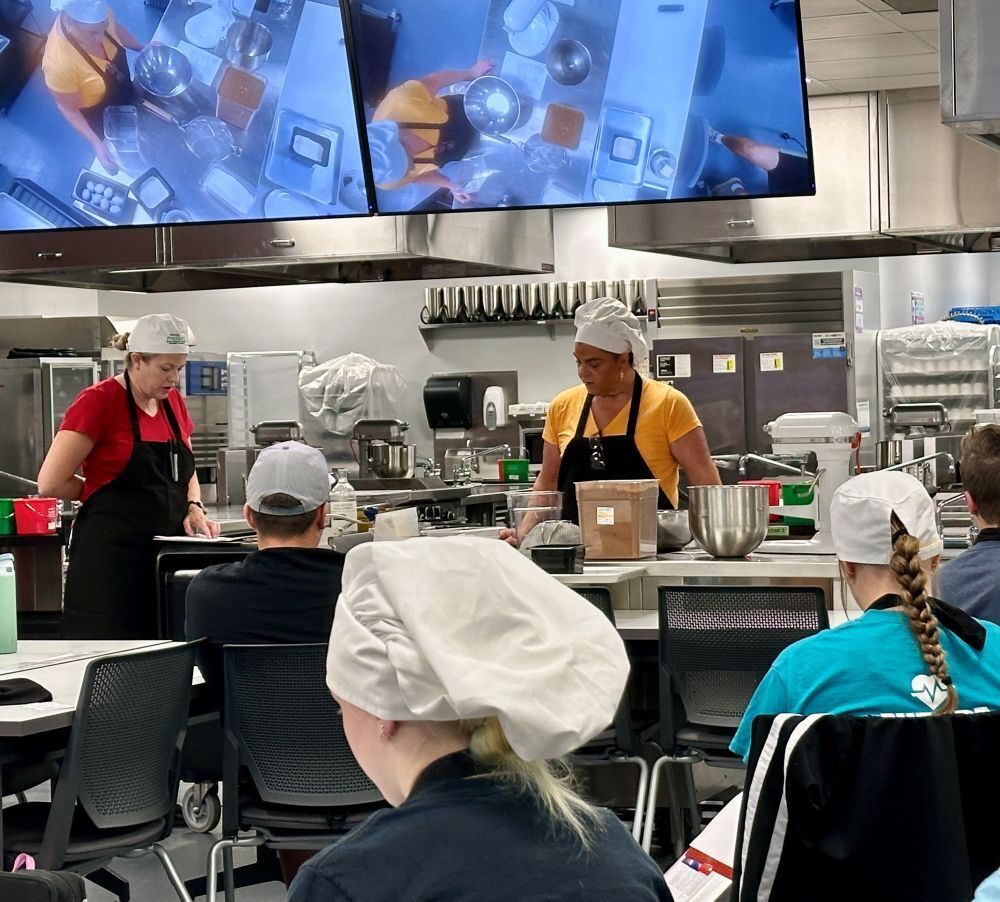 Class listening to instructions on making brownies from  Culinary Arts Instructors