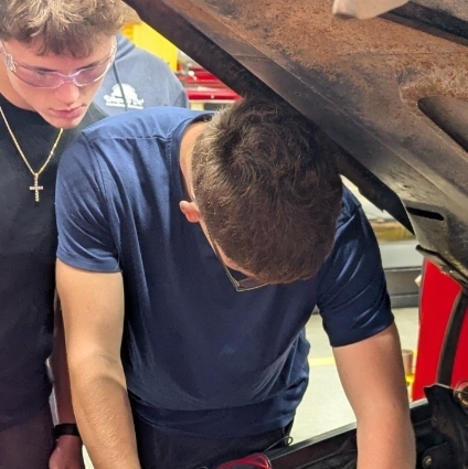working as a team using a multimeter to diagnose a possible issue