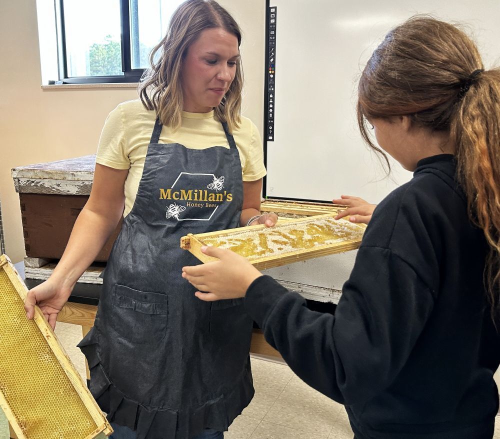 Student learning about bees and tasting honeycomb
