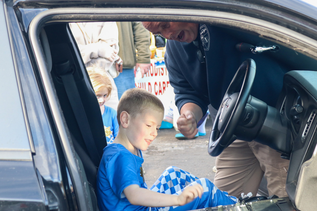 Teacher showing kid how to turn on police car lights