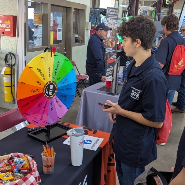A Student spins the wheel at a booth during Diesel Days 