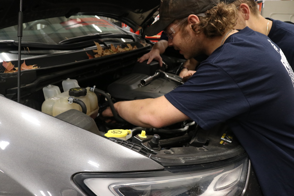 student working hands on in engine 