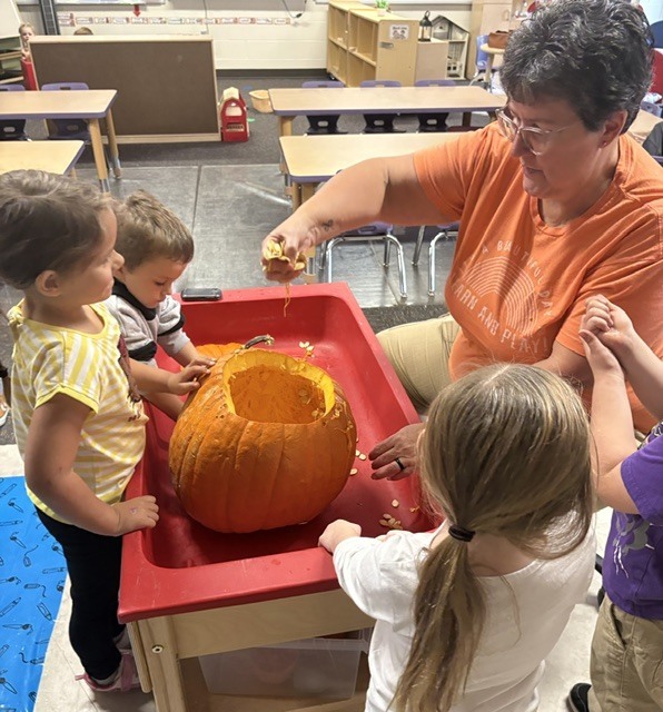 teacher and students exploring inside of pumpkin