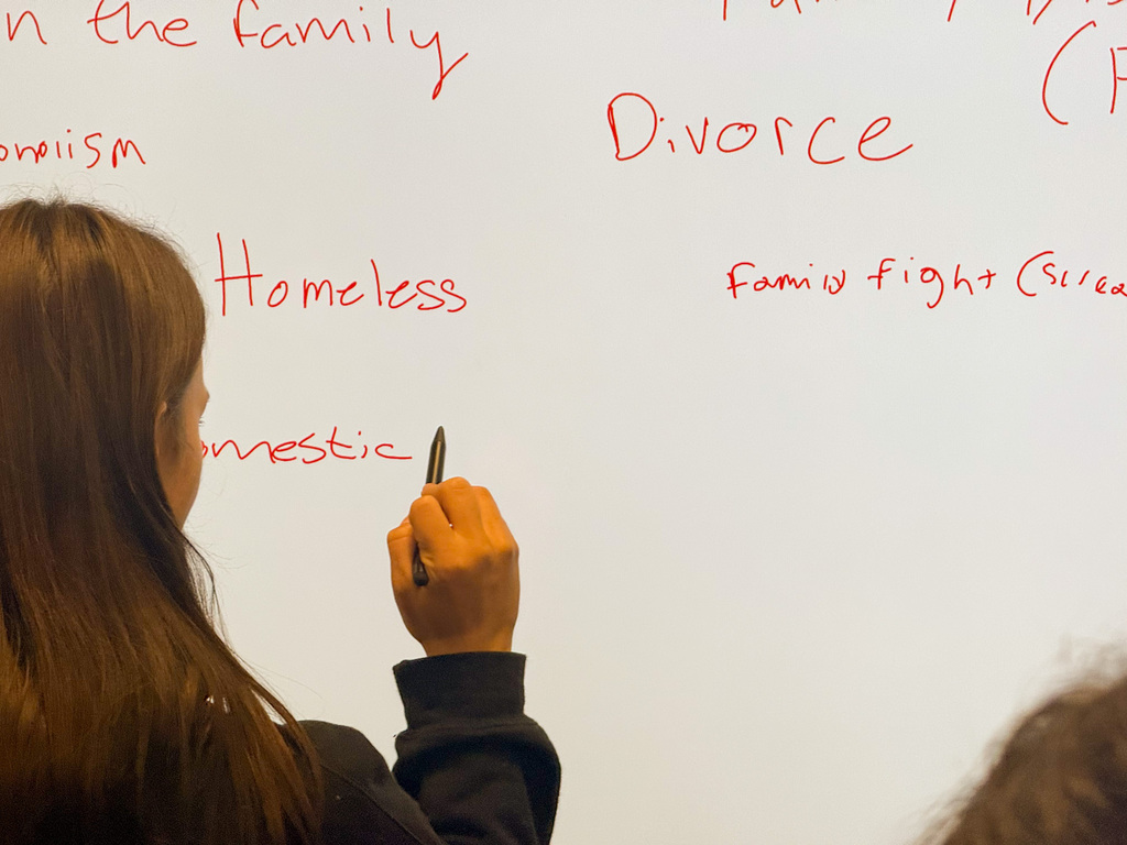 Student writing a learning barrier on a whiteboard