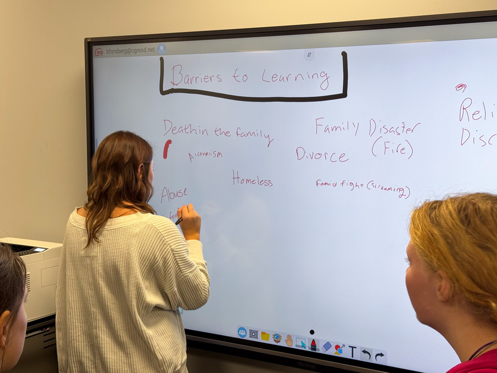 Student writing a learning barrier on a whiteboard