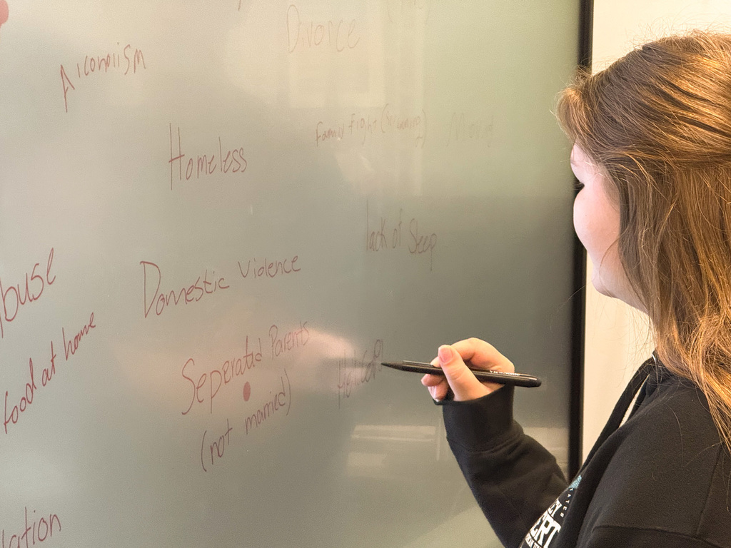 Student writing a learning barrier on a whiteboard
