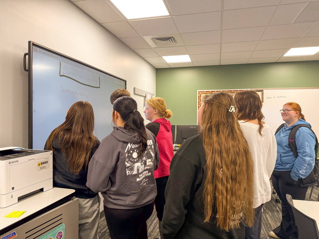 Student writing a learning barrier on a whiteboard