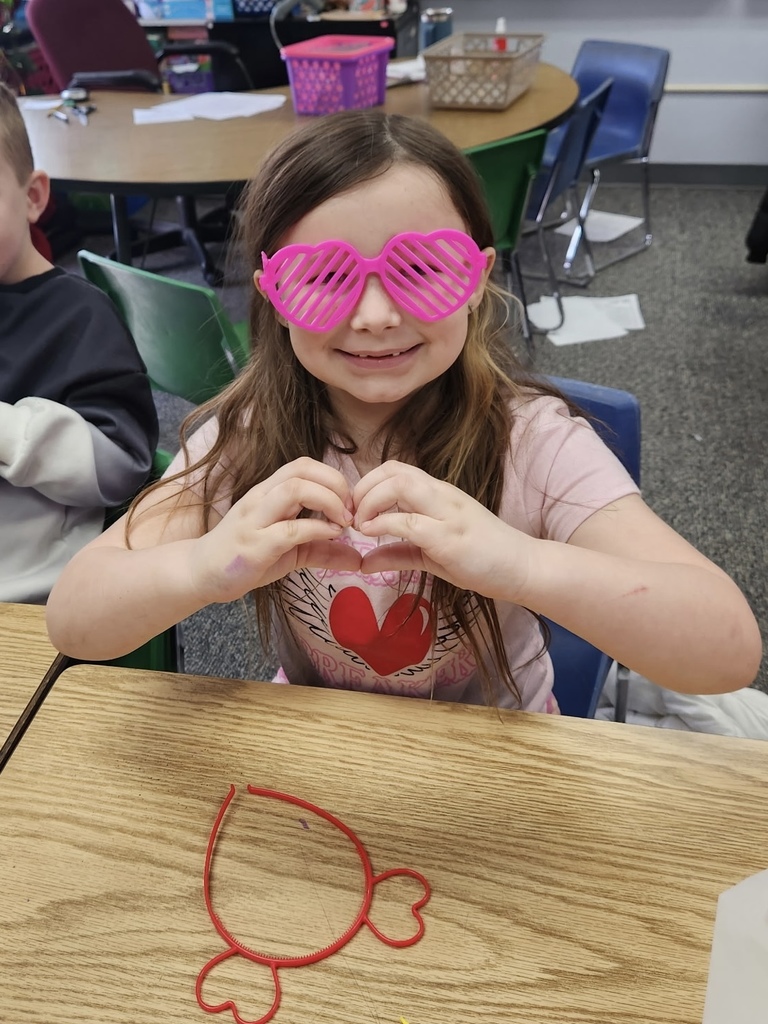 student smiling with cute glasses and making a heart with her hands