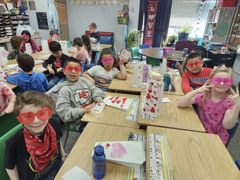 students smiling with their heart shaped glasses on in mrs wards class