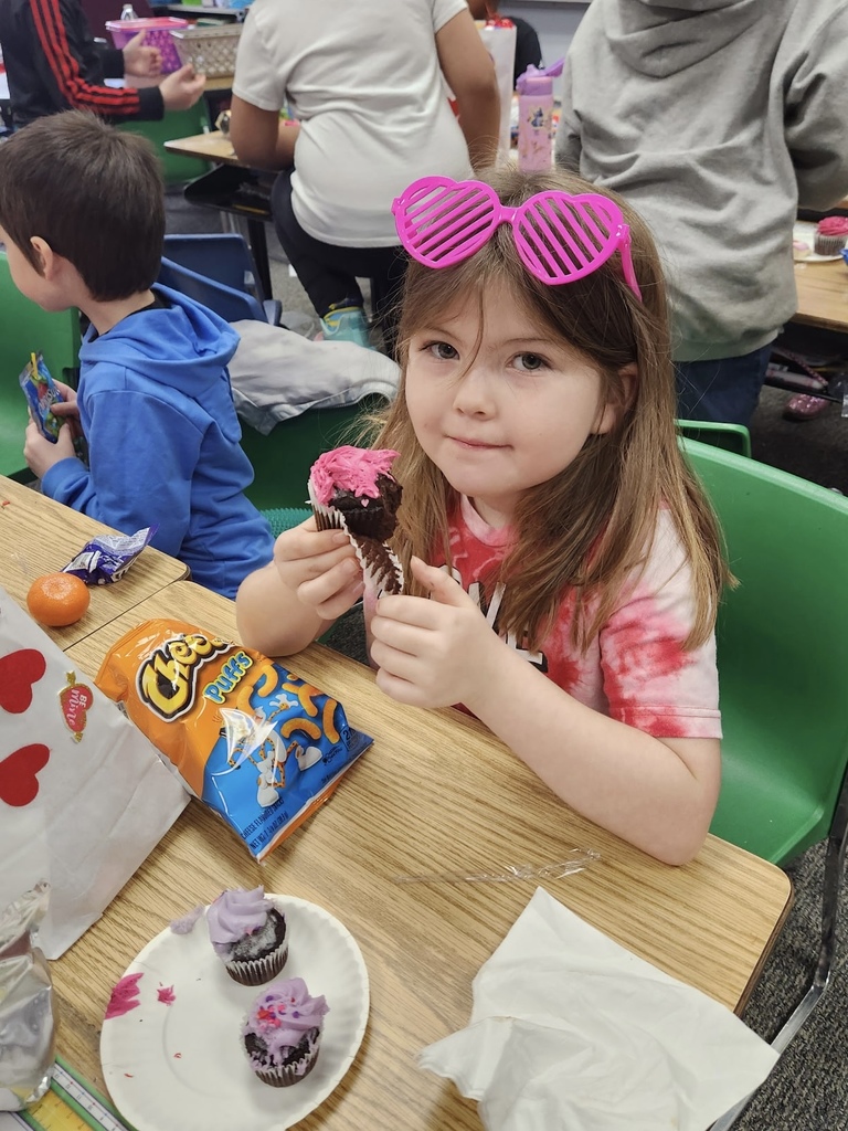student eating cupcake and snacks for class party