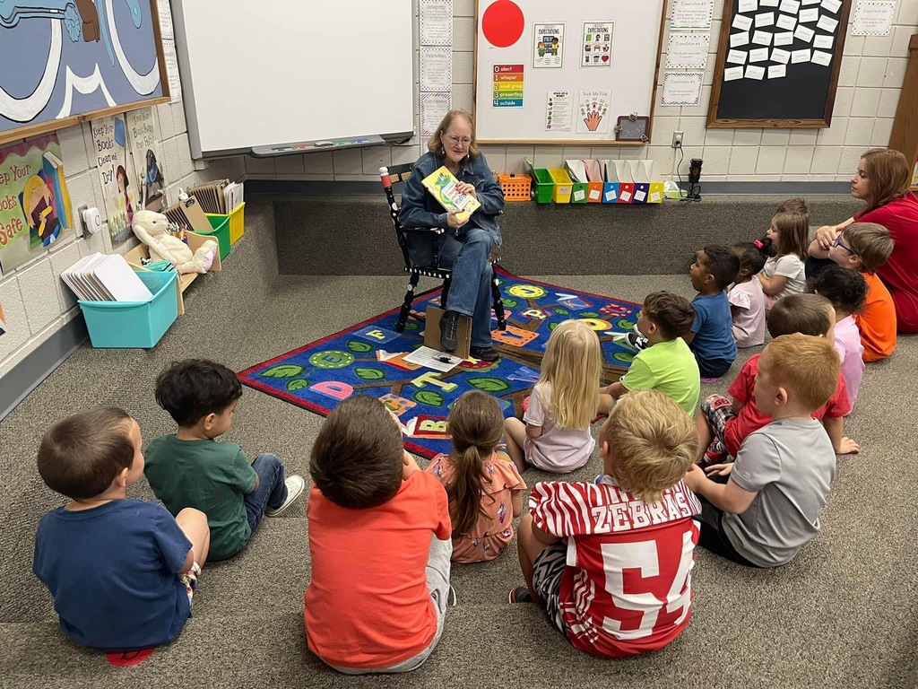 Students listening to librarian read book
