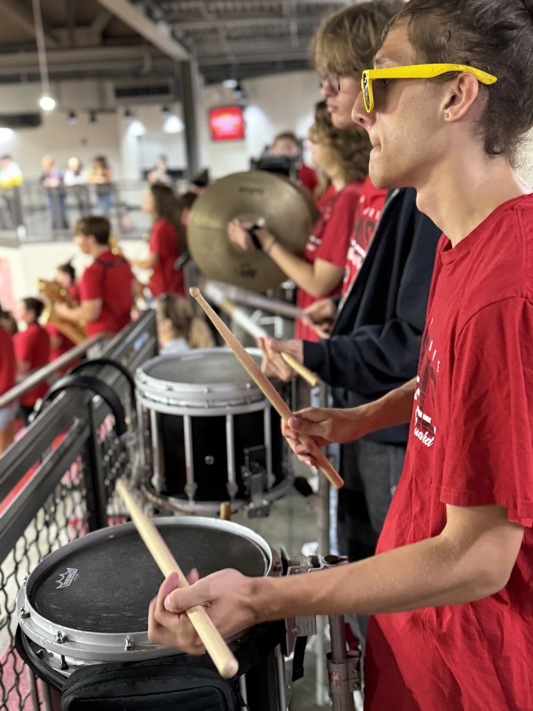 student playing a drum at a pep assembly