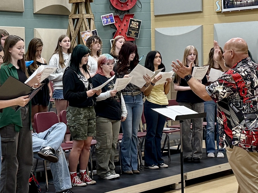 Students being led by choir director to learn new music
