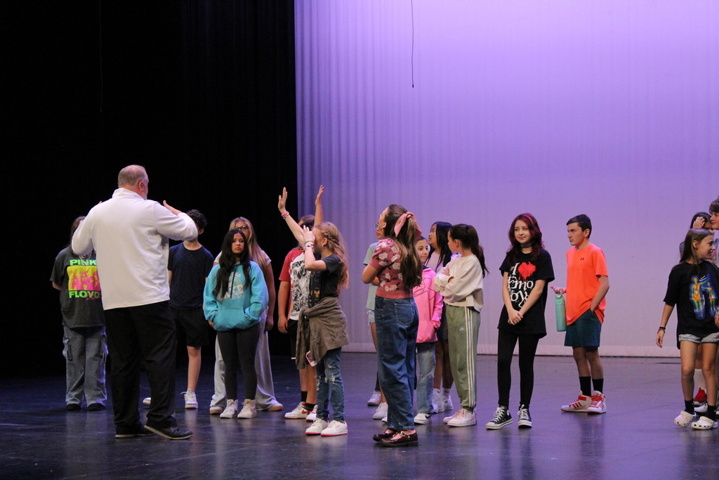 Dr. Adkins on stage with jr high drama