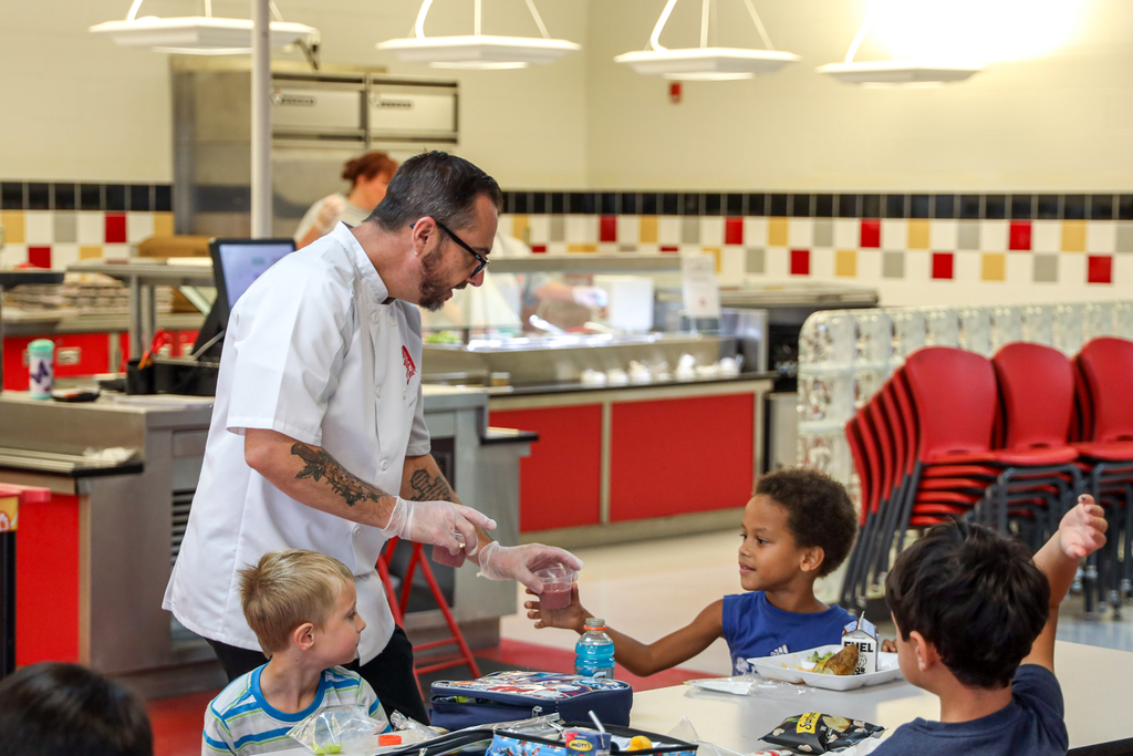 Chef Ryan handing out smoothie to Elementary student