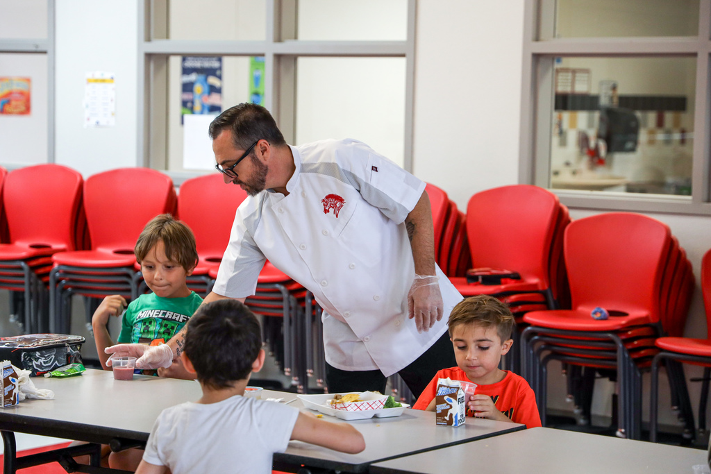 Chef Ryan handing out smoothie to Elementary student