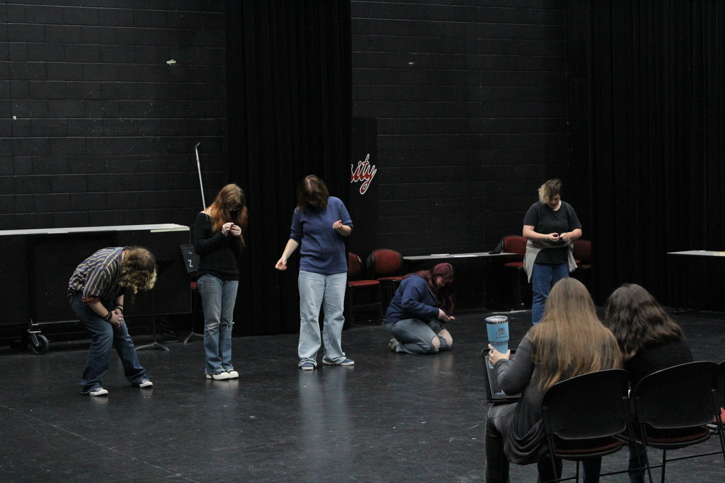 students pretending to struggle with small objects