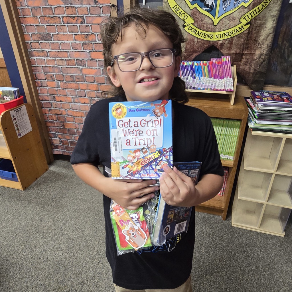 Student holding a book and a prize