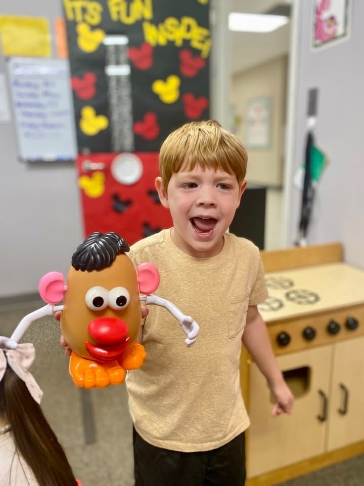 student holds potato toy