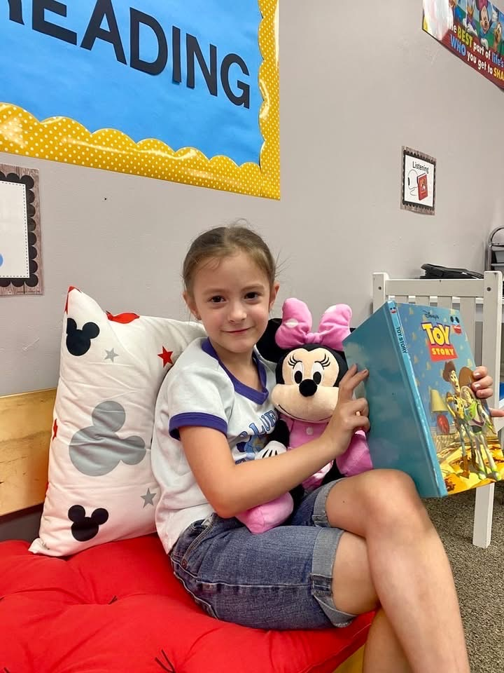 student holds Minnie Mouse sitting on couch