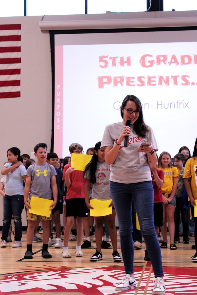 teacher speaking with students in the background