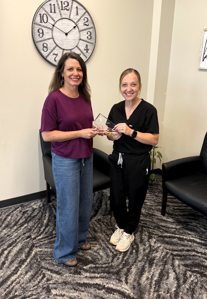 school nurse being presented with certified healthy plaque