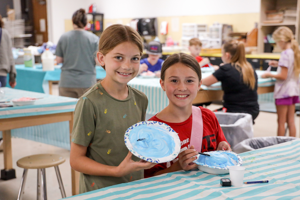 Elementary students showing off art work at Summer Camp 2025