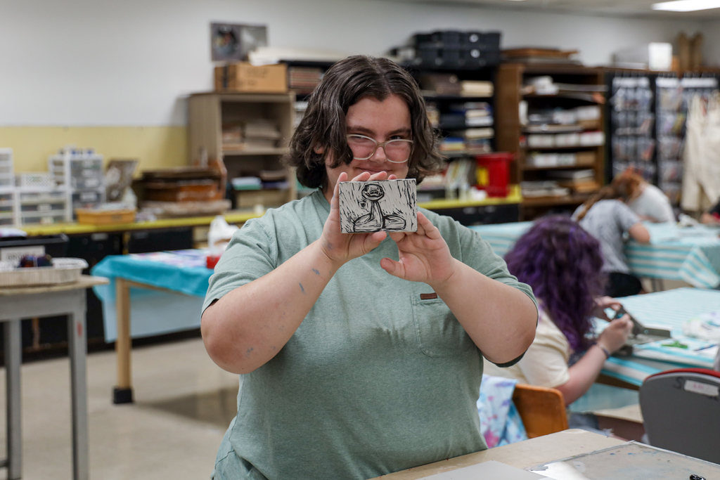 Student showing off art work at Summer Camp 2025