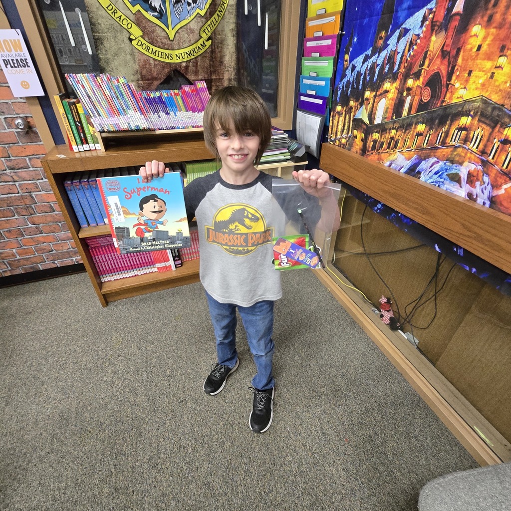 Student holding a book and a prize