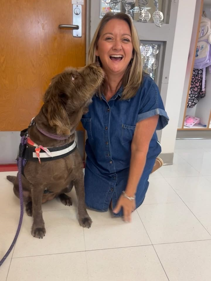 teacher laughing next to dog