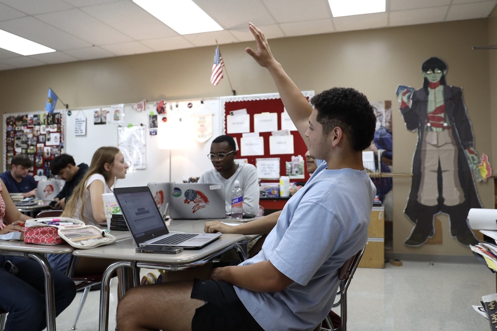 student raising hand to ask a question about his application