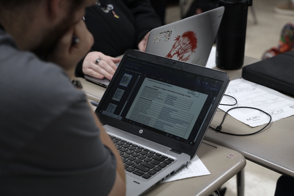 student looking at Oklahoma schools on his computer