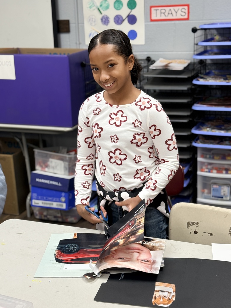 Student smiling as she works on her art work