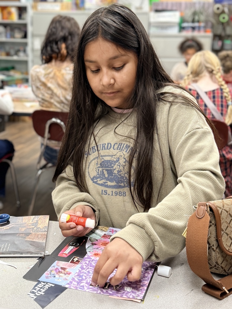Student gluing down her pictures on her collage