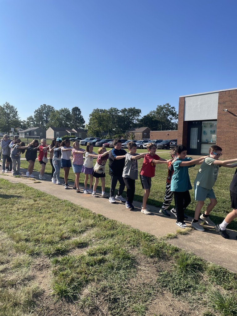 students walking with their hands on friends shoulders