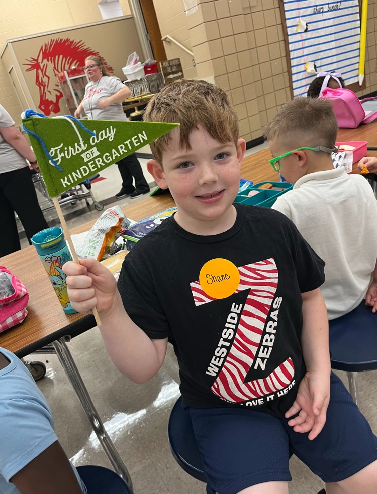 students posing with first day of school flags