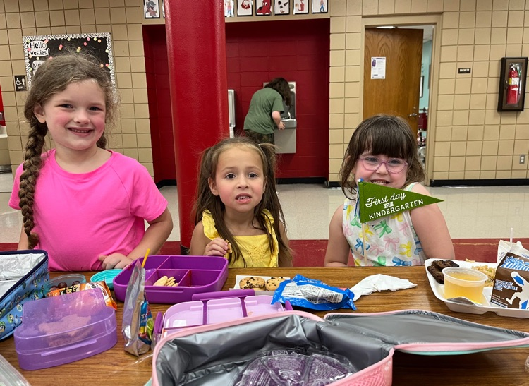 students posing with first day of school flags