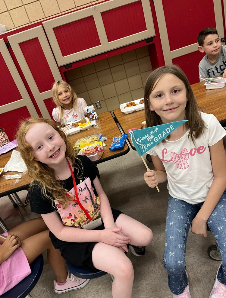 students posing with first day of school flags