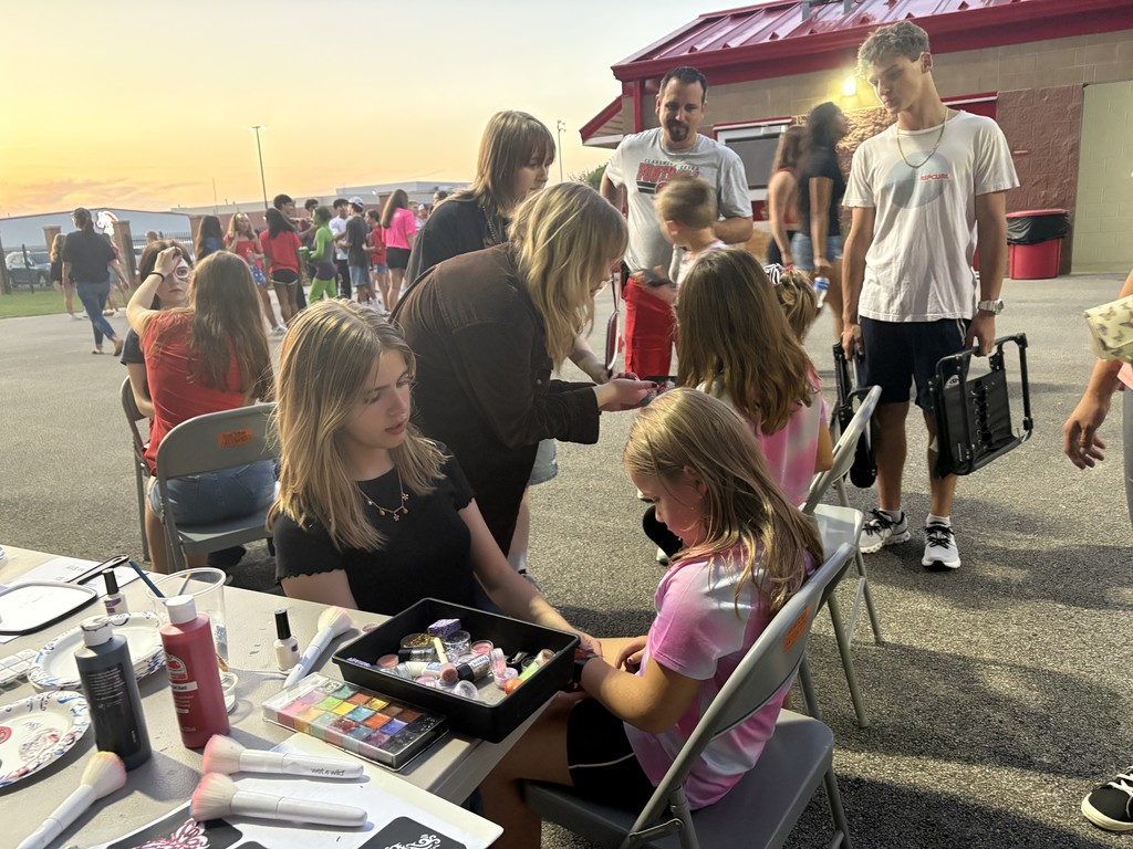 kids getting their faces painted at the football game